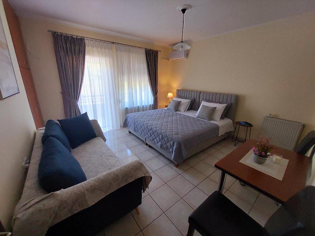 sypialnia z łóżkiem, kanapą i stołem w obiekcie Eleni's Apartments Igoumenitsa - Γκαρσονιέρα 2ου ορόφου επιπλωμένη, εξοπλισμένη w mieście Igoumenitsa