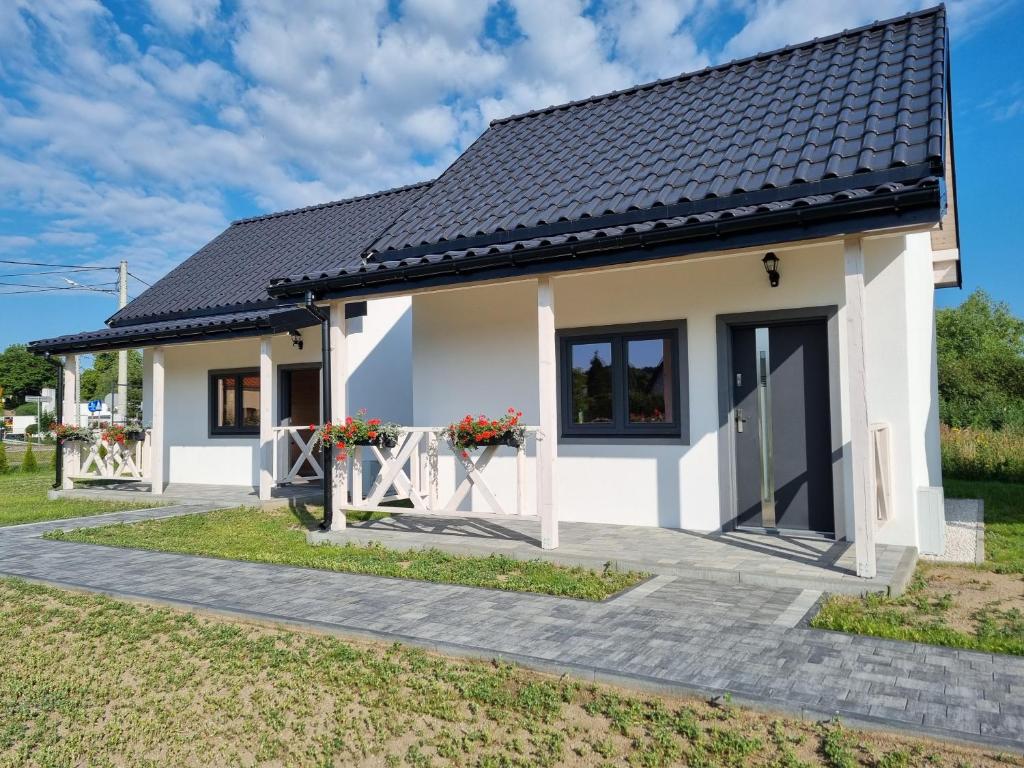 a white house with a black roof at Przystań Tolkmicko in Tolkmicko