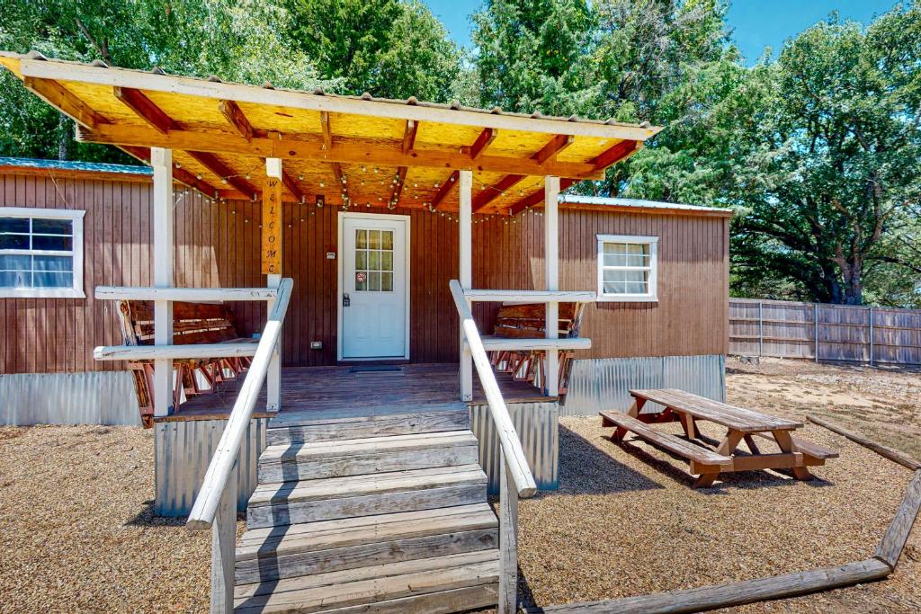 a wooden deck with a wooden pergola and benches at Landyn's Lakeside Lodge in Kemp