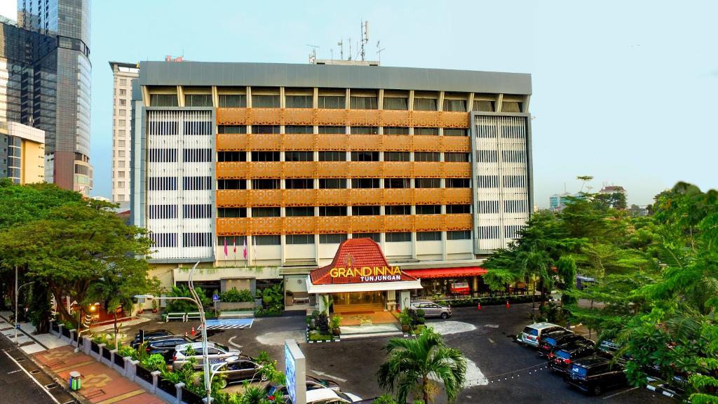 a large building with a parking lot in front of it at Grand Inna Tunjungan in Surabaya