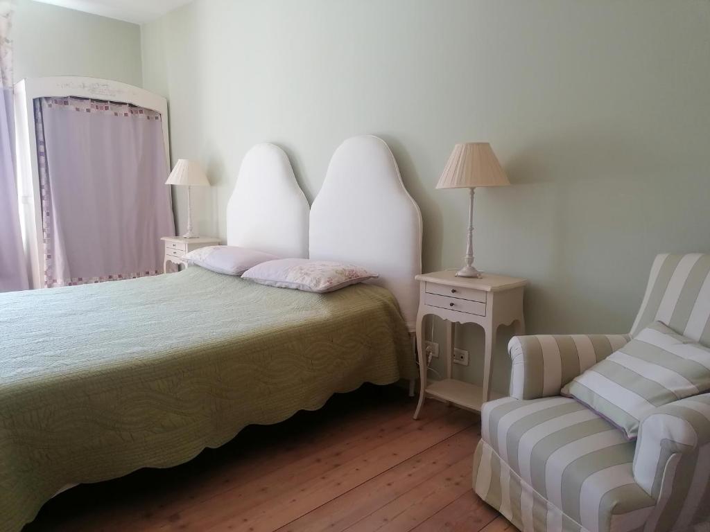 ein Schlafzimmer mit einem Bett und einem Stuhl darin in der Unterkunft LAVANDA appartamento in Vigliano Biellese