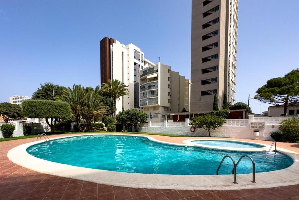 una piscina en una ciudad con edificios altos en Calpe apartamento lujoso bajo terasa piscina aire cerca playa pueblo, en Calpe