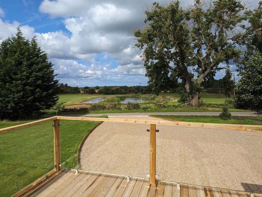 eine Holzterrasse mit Parkblick in der Unterkunft Gosling Lodge in Durham