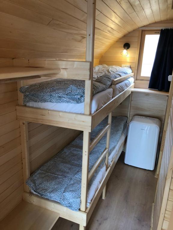 a room with four bunk beds in a tiny house at Zatoka Marina in Mechelinki