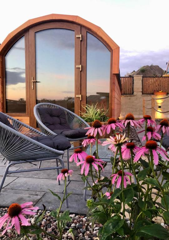 a patio with chairs and flowers and a gazebo at Zatoka Marina IV in Mechelinki