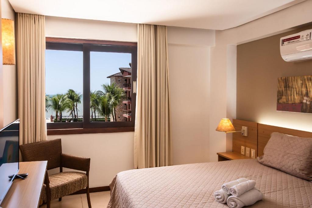 - une chambre avec un lit, un bureau et une fenêtre dans l'établissement Linda Suíte em Apart-hotel com vista incrível!!!, à Cumbuco