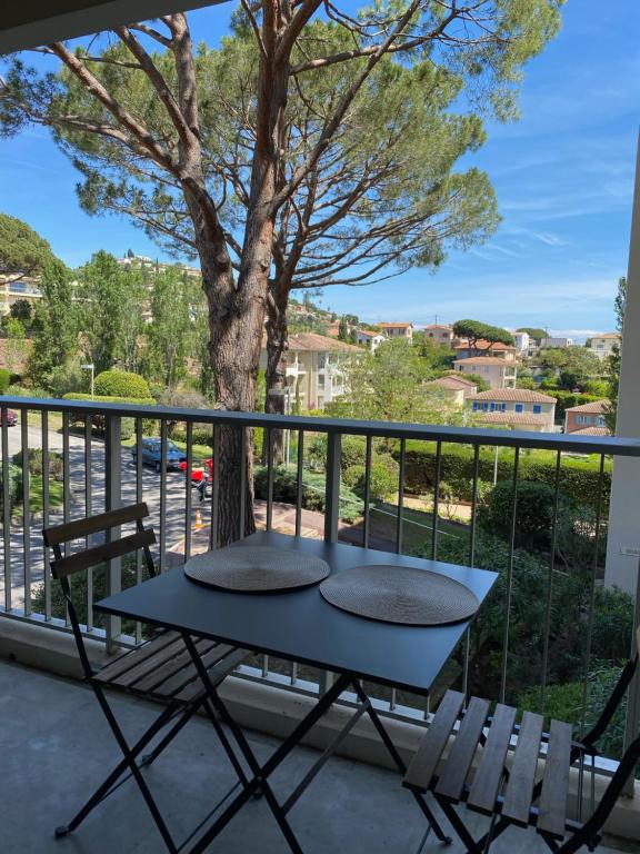 une table et des chaises sur un balcon avec un arbre dans l'établissement Studio à Golfe Juan, terrace, piscine, près plages, à Vallauris