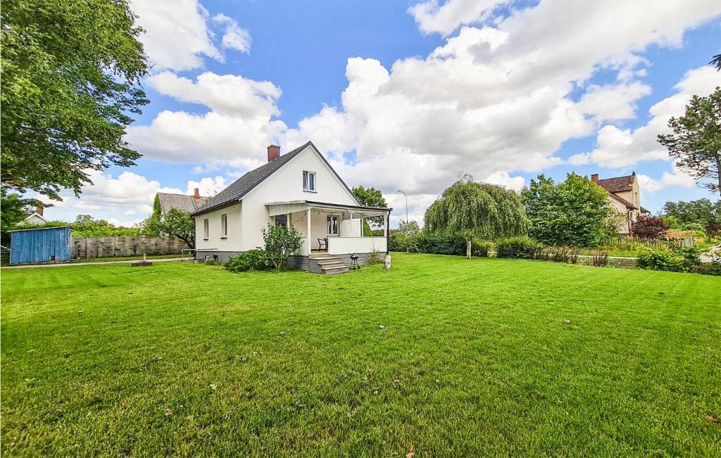 a white house in a yard with a green lawn at Lovely Home In Lvestad With House A Panoramic View in Lövestad