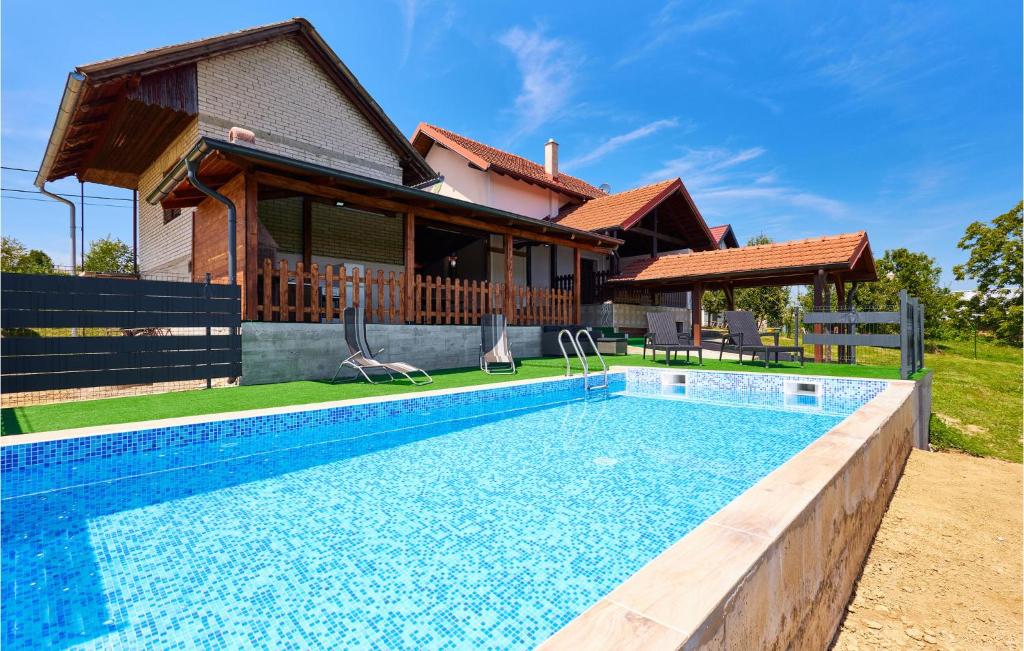 a swimming pool in front of a house at Beautiful Home In Beslinec With Outdoor Swimming Pool 
