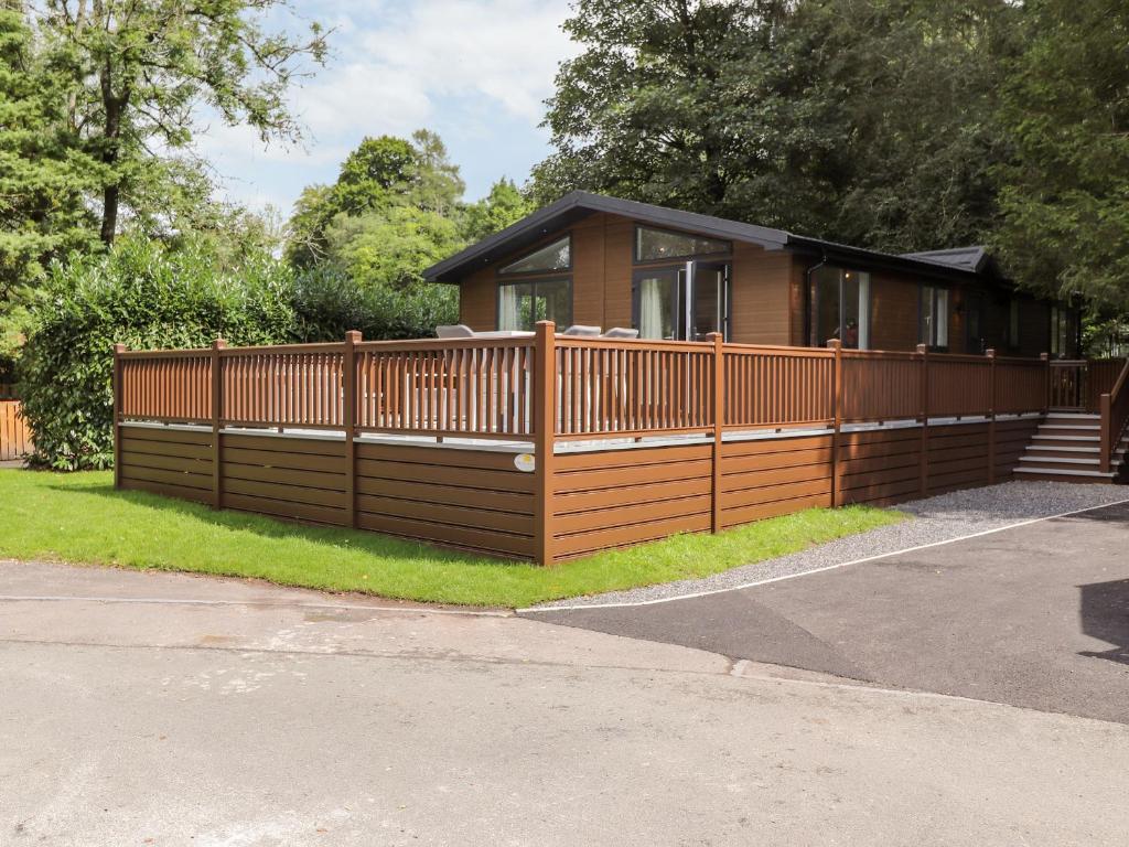 a house with a wooden fence in front of it at Unique Luxury Lodge in Windermere