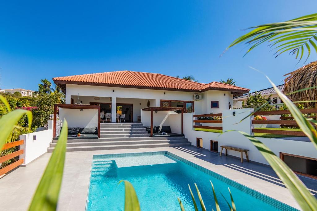 a villa with a swimming pool and a house at Villa Blou, steps from the Jan Thiel Beach in Jan Thiel