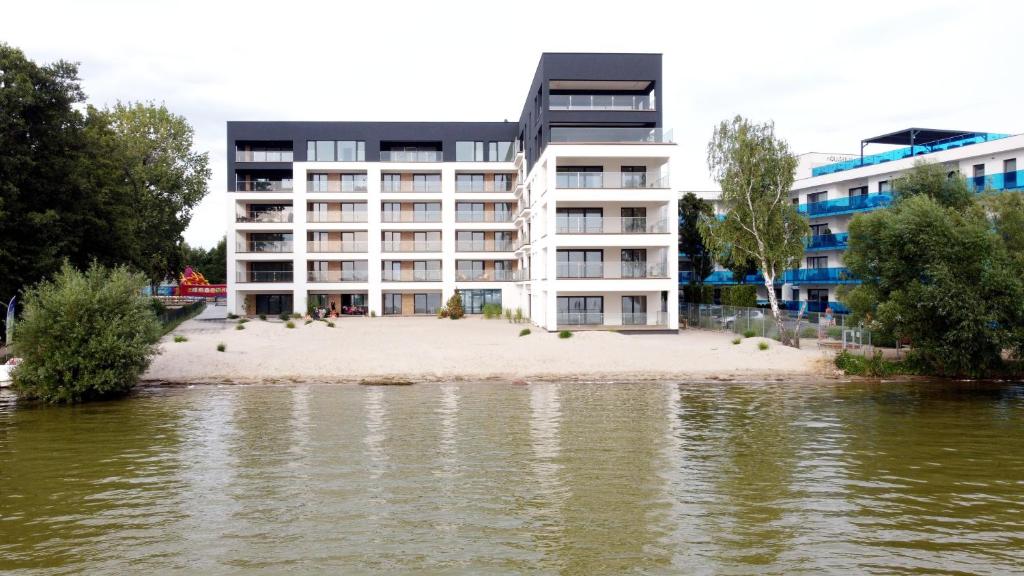 博斯科沃的住宿－Apartamenty Horizon Sunset Boszkowo，海滩上的一座建筑,靠近一片水域
