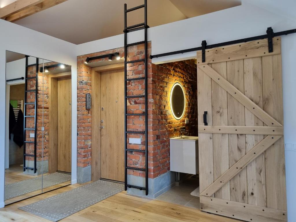 a barn door in a room with a brick wall at Old Town Apartment with Netflix and AC in Kaunas