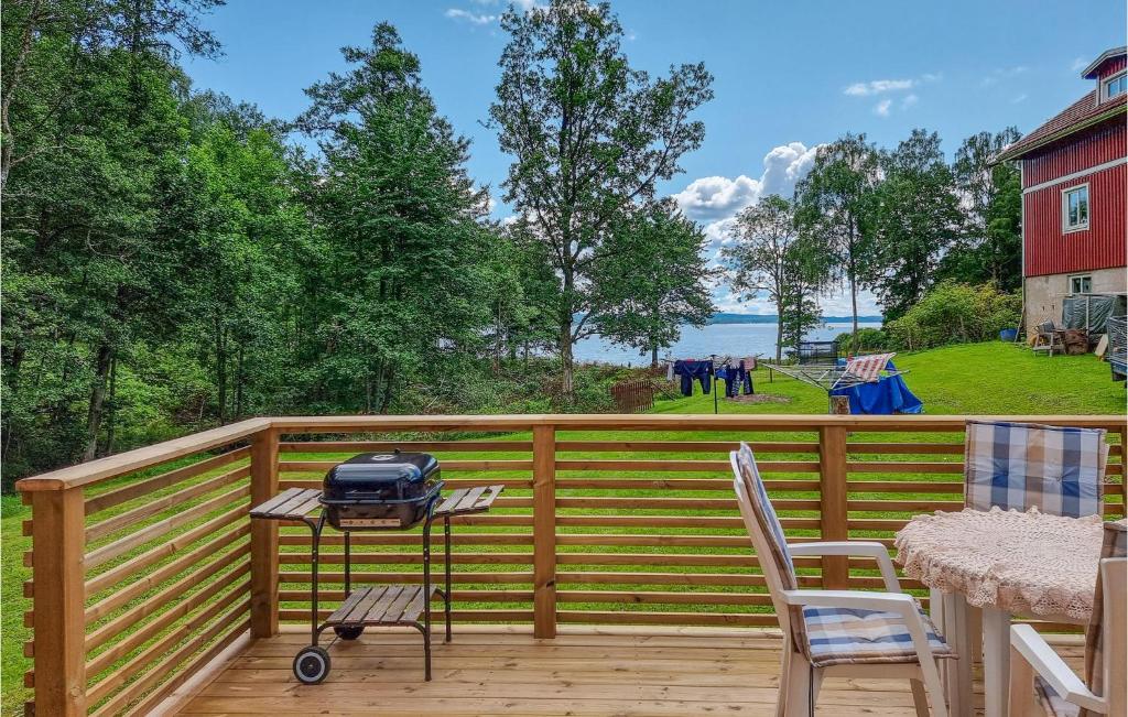 a patio with a grill on a wooden deck at Lovely Home In Alingss With Wifi in Alingsås