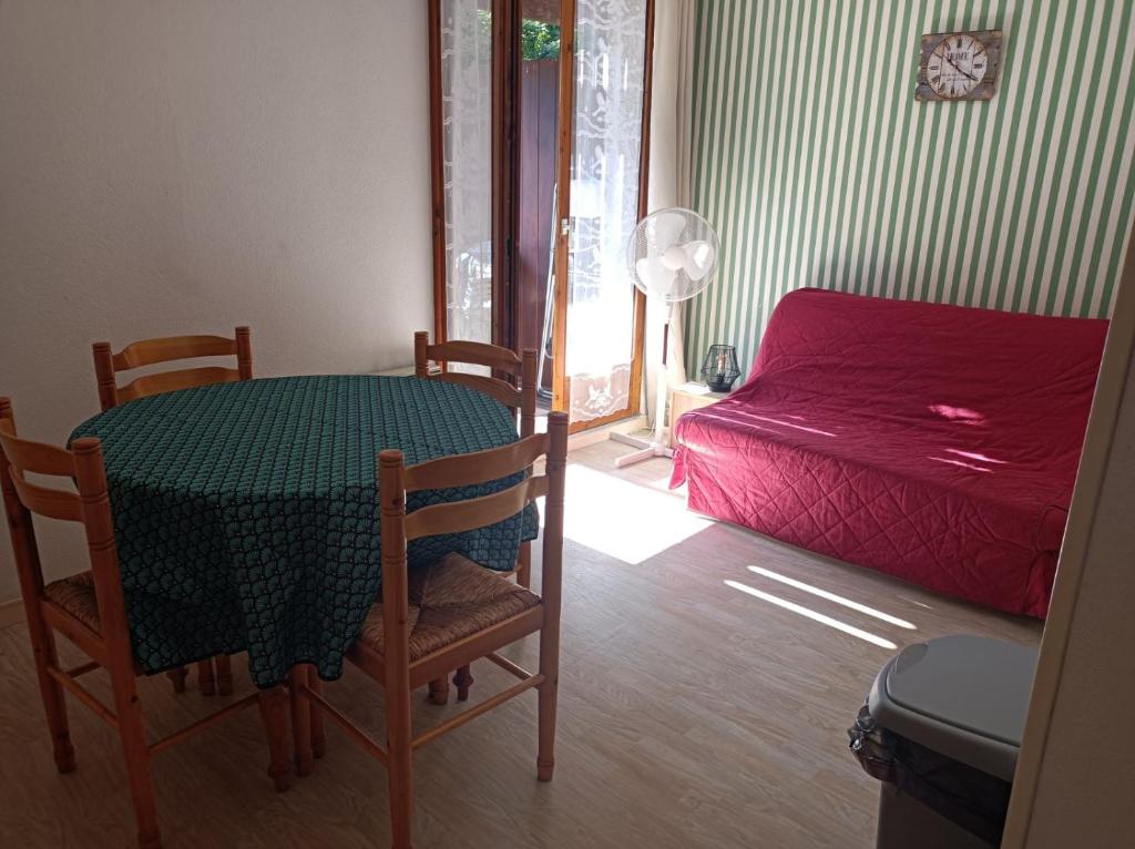 a small room with a table and a bed at Appartement entre thermes et montagne in Luchon