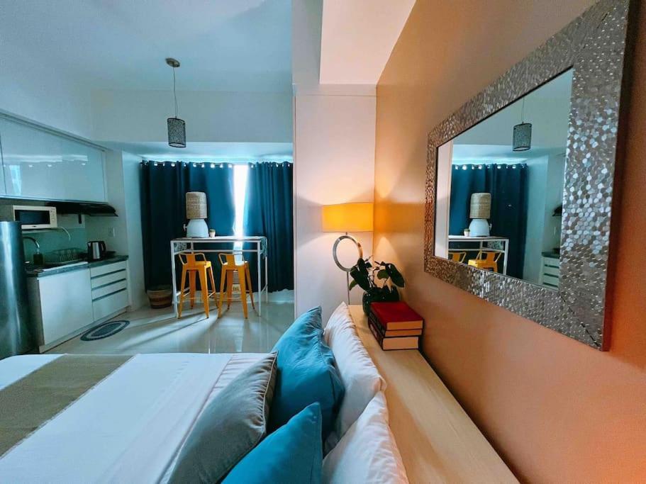 a bedroom with a bed and a mirror on the wall at Calyx Residences by Hooga Home 3minutes walk to Ayala Center Cebu in Cebu City