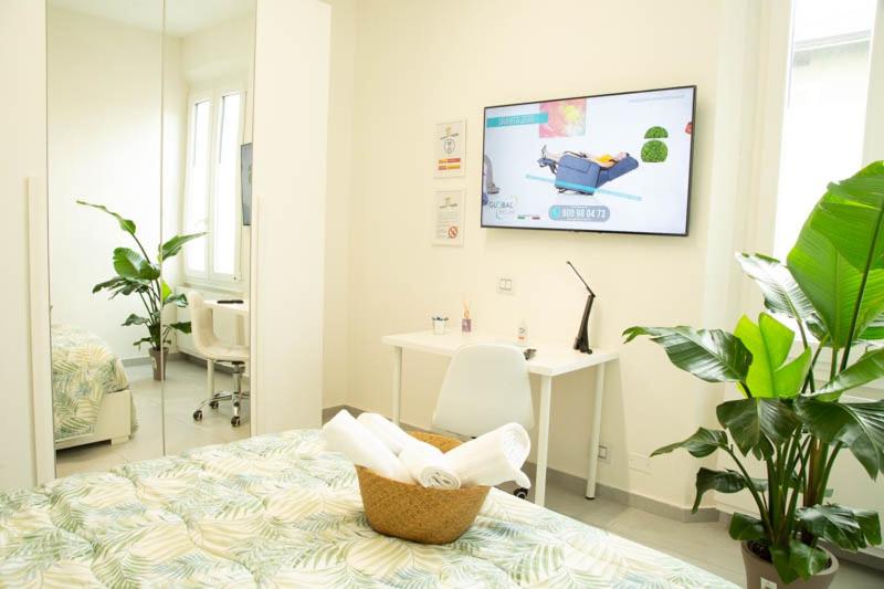 una camera ospedaliera con un letto e una TV a muro di Guest House Garden dei Mille a Reggio Emilia