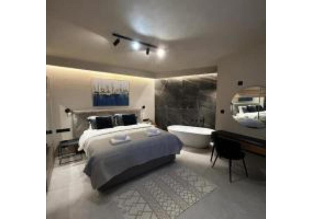 a bedroom with a large bed and a bath tub at On The Sea Suite&Spa in Methana
