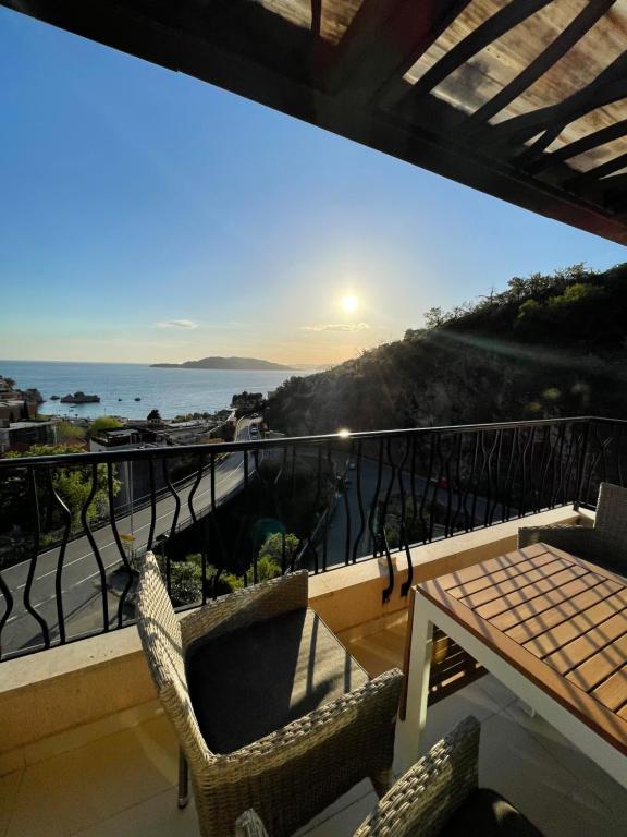 Un balcón con mesa y sillas y el mar. en Miločer Apartman Beograd, en Pržno