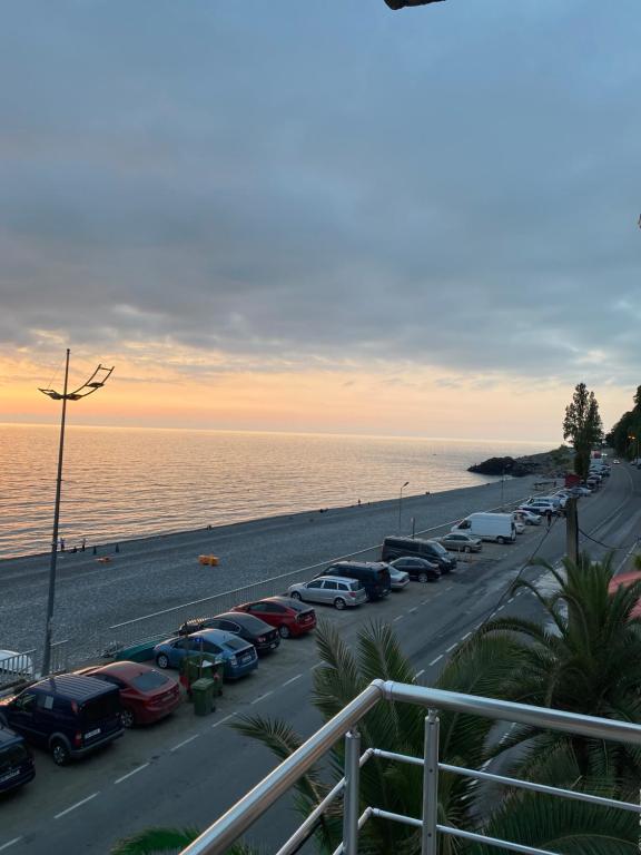 a parking lot with cars parked next to the beach at SARPI HOTEL NUMA in Sarpi