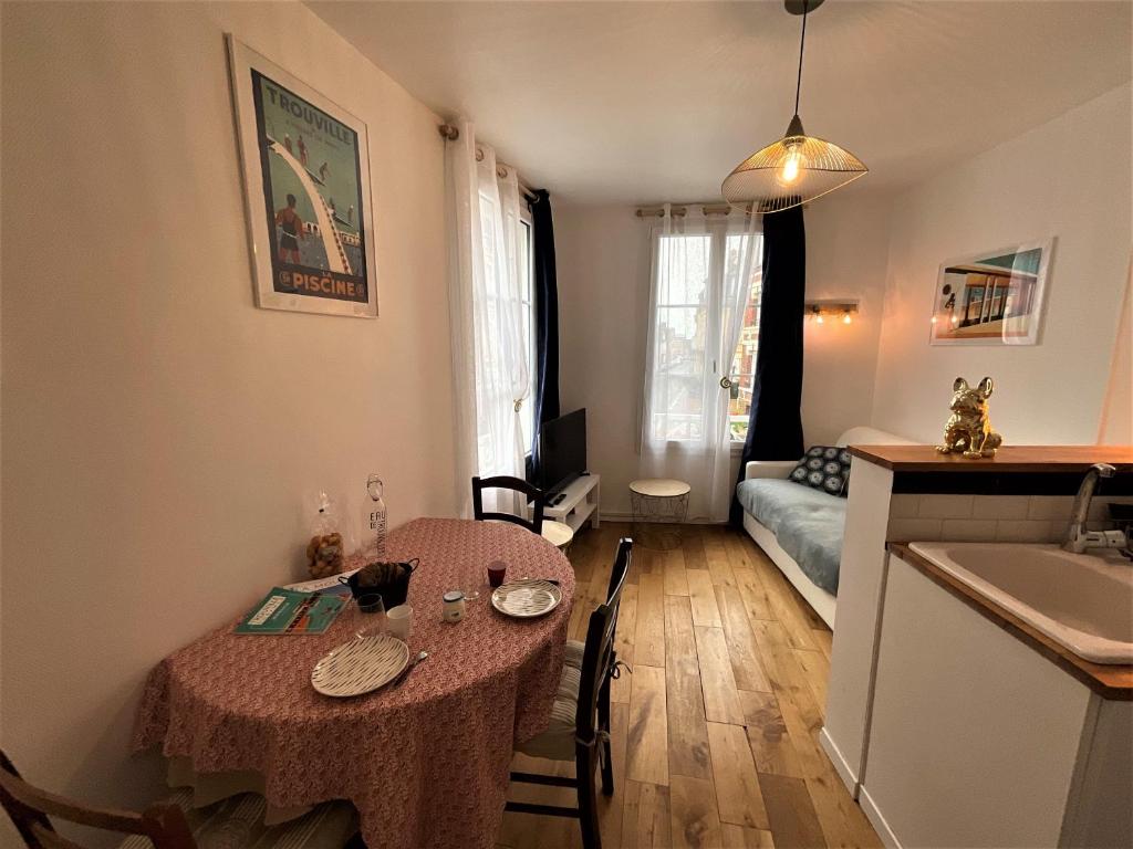 un salon avec une table et une cuisine dans l'établissement Petite Bulle, à Trouville-sur-Mer