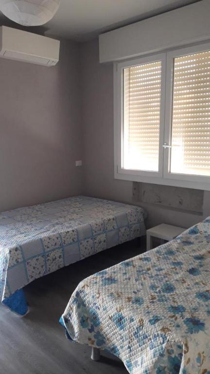 1 dormitorio con 2 camas y 2 ventanas en VeniceMaskPadova, en Padua