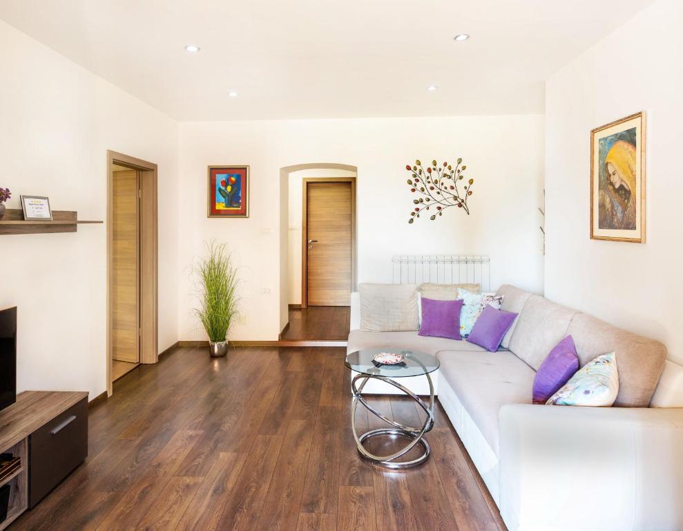 - un salon avec un canapé blanc et une table dans l'établissement Apartment Ivana, à Roč