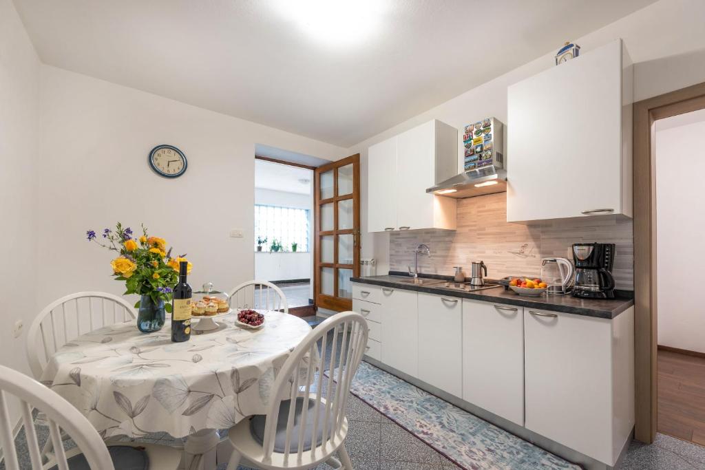 a kitchen and dining room with a table and chairs at Apartment Ivana in Roč