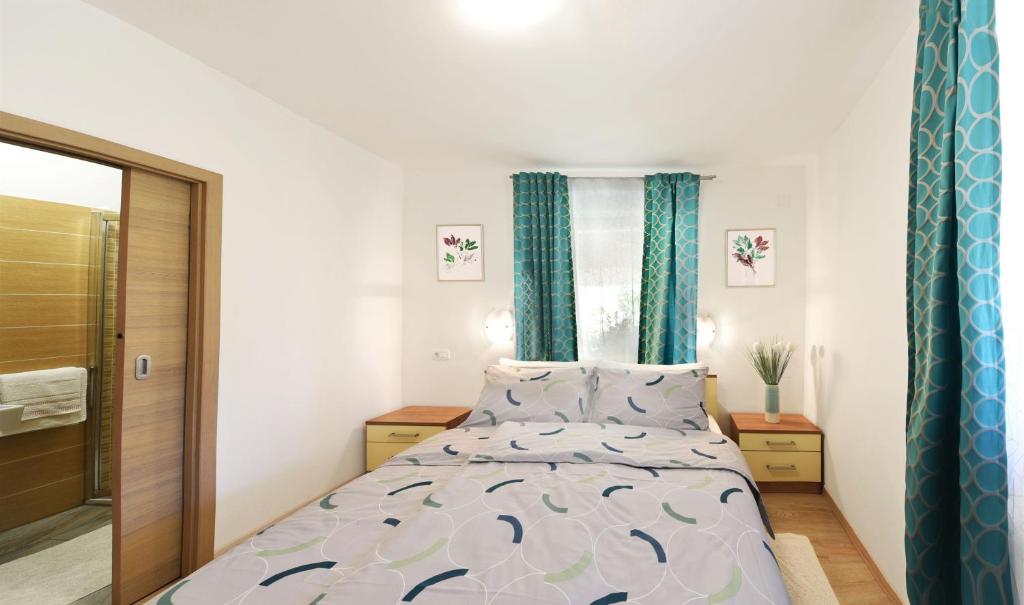 a bedroom with a bed and a window with blue curtains at Apartment Ivana in Roč