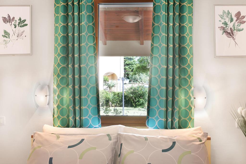 a bedroom with green and white curtains and a window at Apartment Ivana in Roč