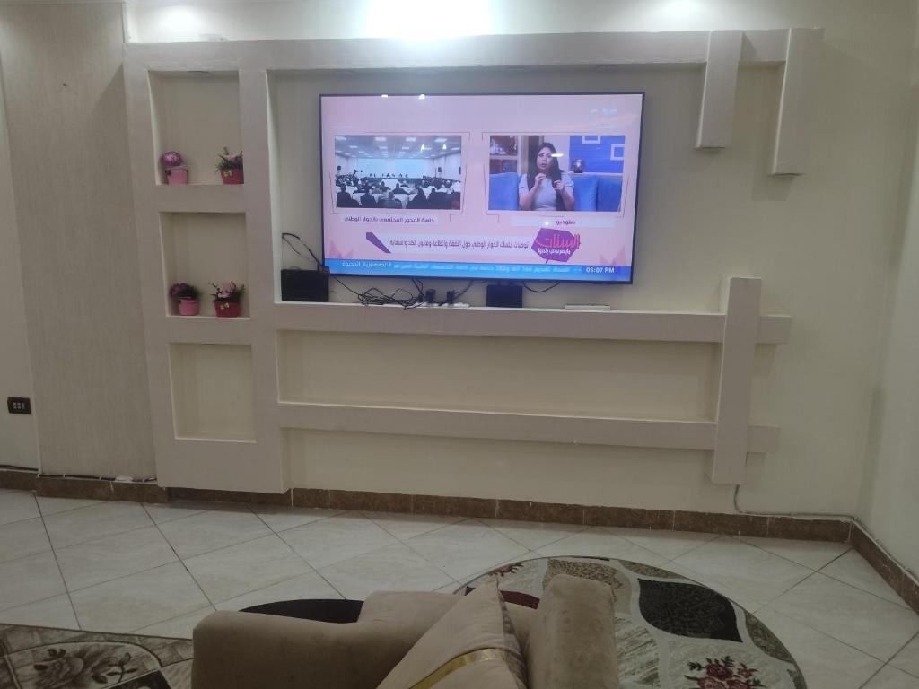 uma sala de estar com uma televisão de ecrã plano na parede em القاهره no Cairo