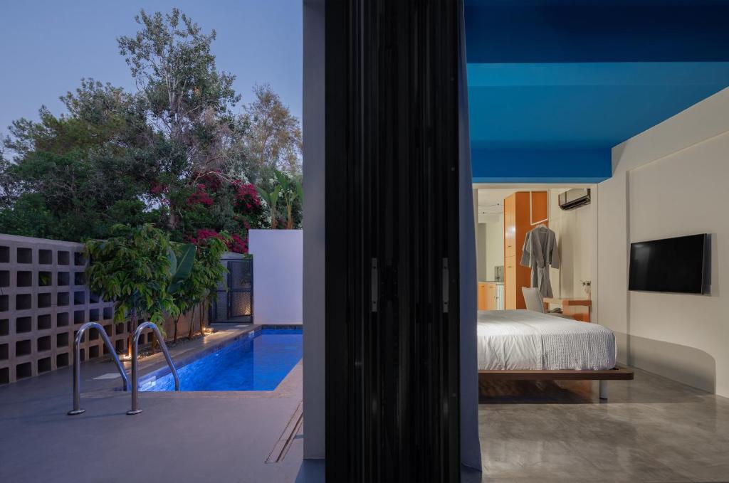 a bedroom with a bed and a swimming pool at Adrop Pool Suites in Paphos