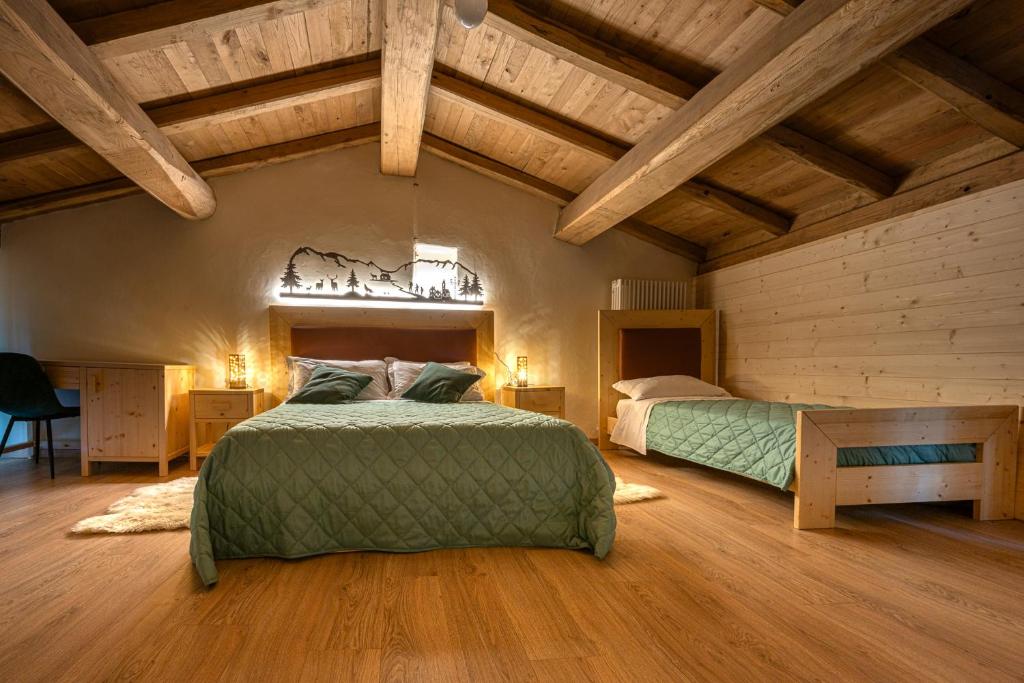 2 Betten in einem Zimmer mit Holzdecken in der Unterkunft Borgo dei Sassi di Roccamalatina - Room and Breakfast in Rocca Malatina