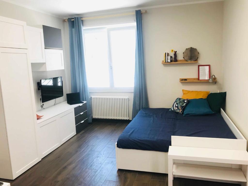 een kleine slaapkamer met een bed en een televisie bij Donna Flor casa vacanze in Barletta