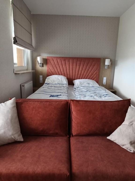 ein großes Bett mit roten Sitzen in einem Schlafzimmer in der Unterkunft BelMare 327 Aqua in Misdroy