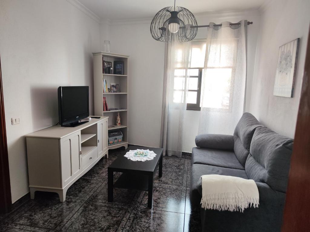 ein Wohnzimmer mit einem Sofa und einem TV in der Unterkunft Bernal I, II y III in Los Sauces