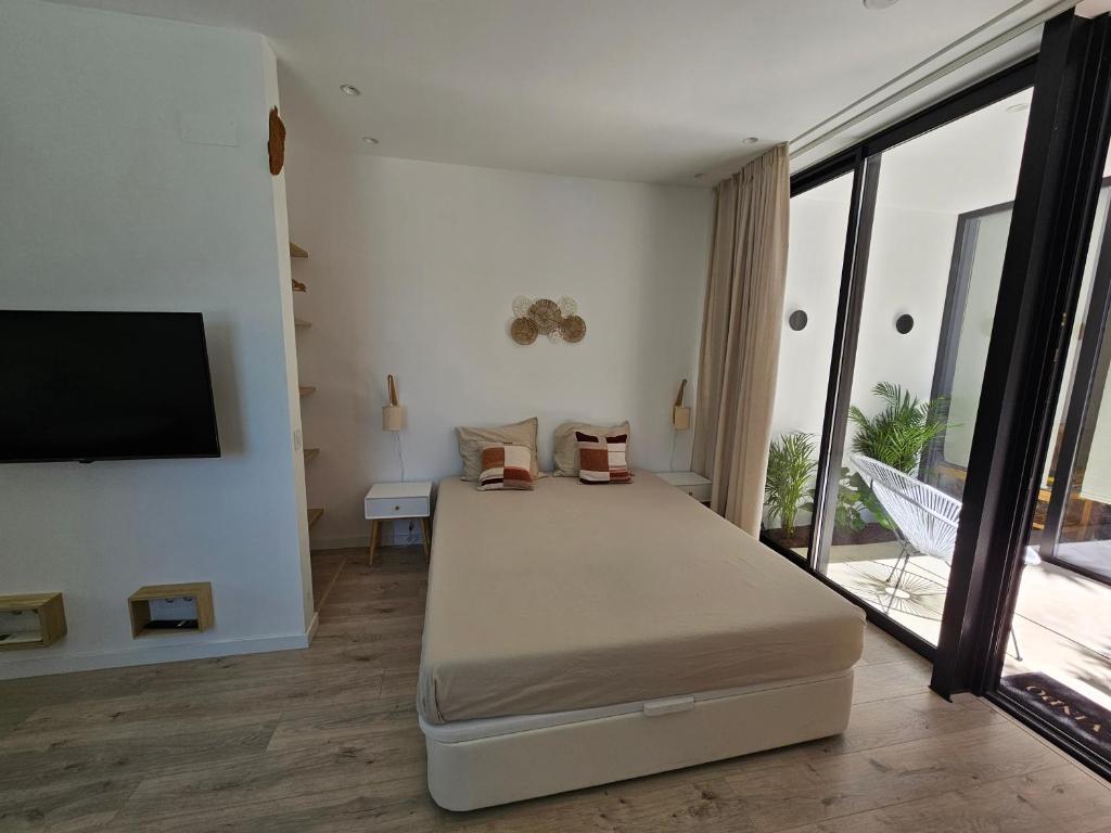 a bedroom with a bed and a flat screen tv at The Singular - Downtown Studio in Faro