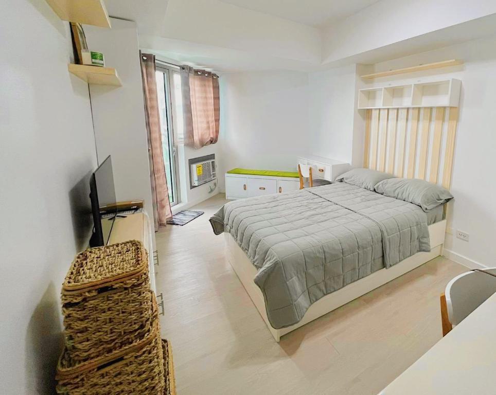 een slaapkamer met een bed en een televisie. bij Azure North Residences by ACC in Lagundi