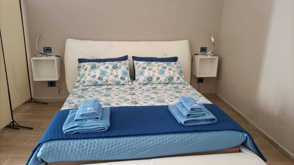 een slaapkamer met een bed met blauwe lakens en kussens bij Il rifugio del folletto in Santeramo in Colle