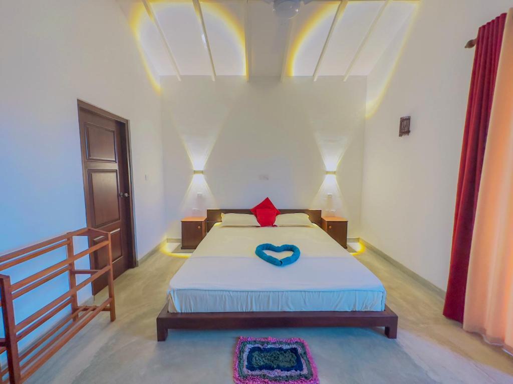 a bedroom with a bed with a blue heart on it at Sayuru Villa in Hikkaduwa