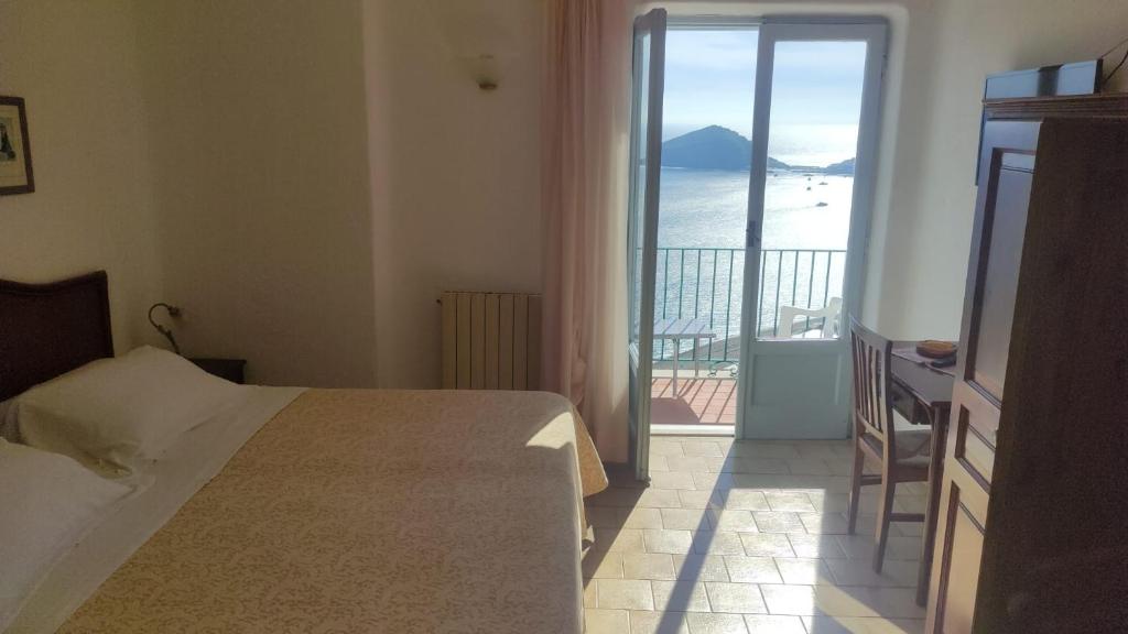 a bedroom with a bed and a view of the ocean at Hotel Villa al Mare in Ischia