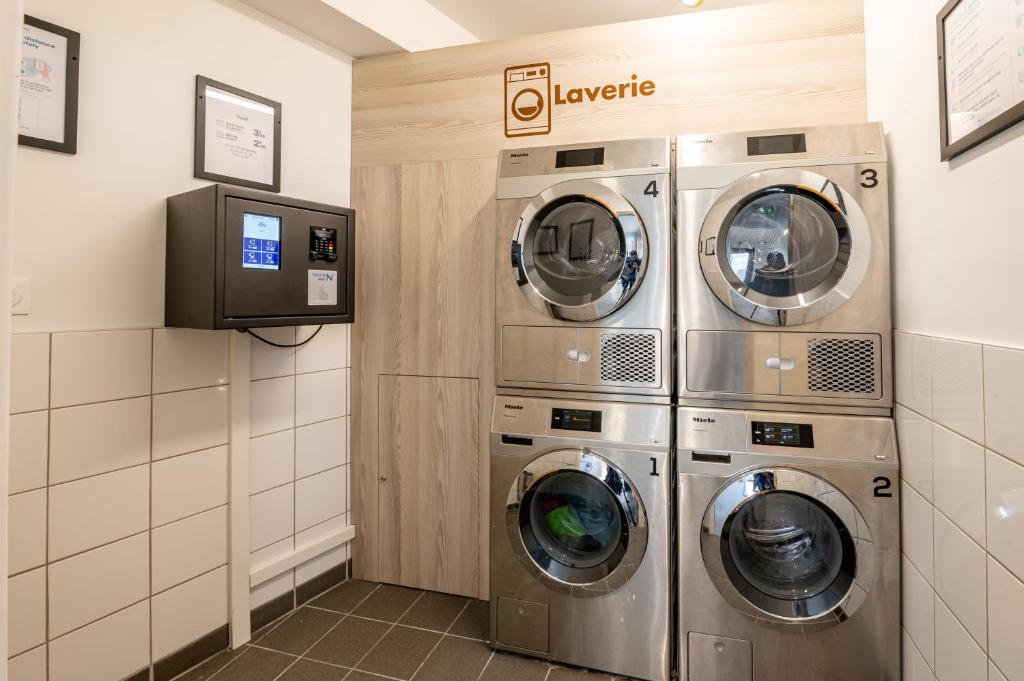 a laundry room with three washing machines in it at UCPA SPORT STATION HOSTEL PARIS in Paris