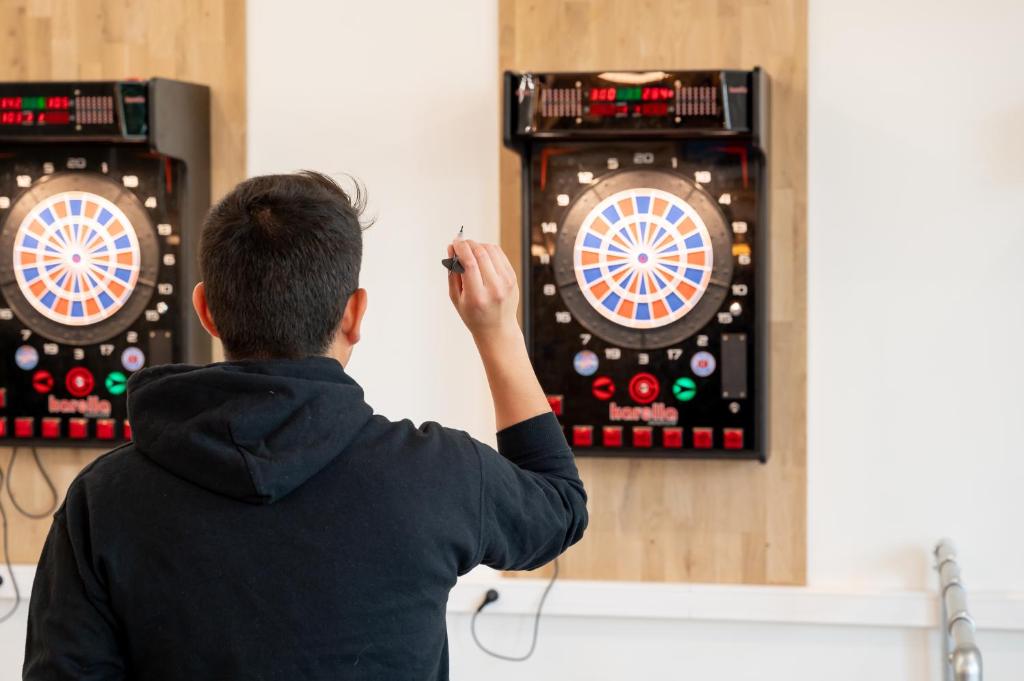 a man playing darts on a dart board at UCPA SPORT STATION HOSTEL PARIS in Paris