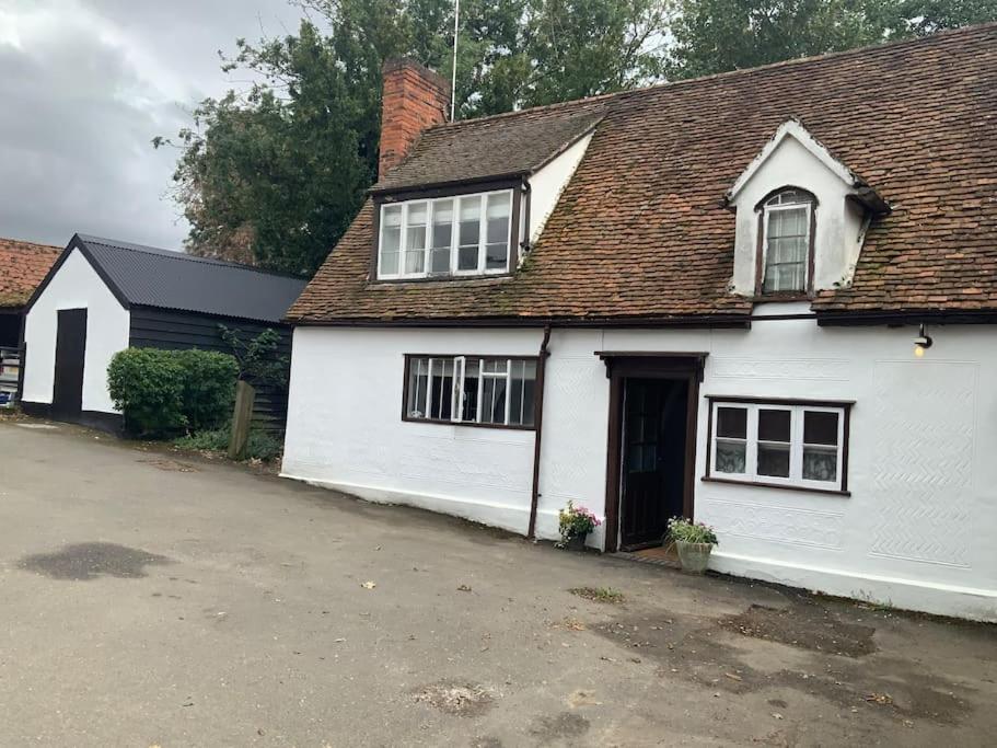 a white house with a brown roof at Cosy Cottage in Sawbridgeworth