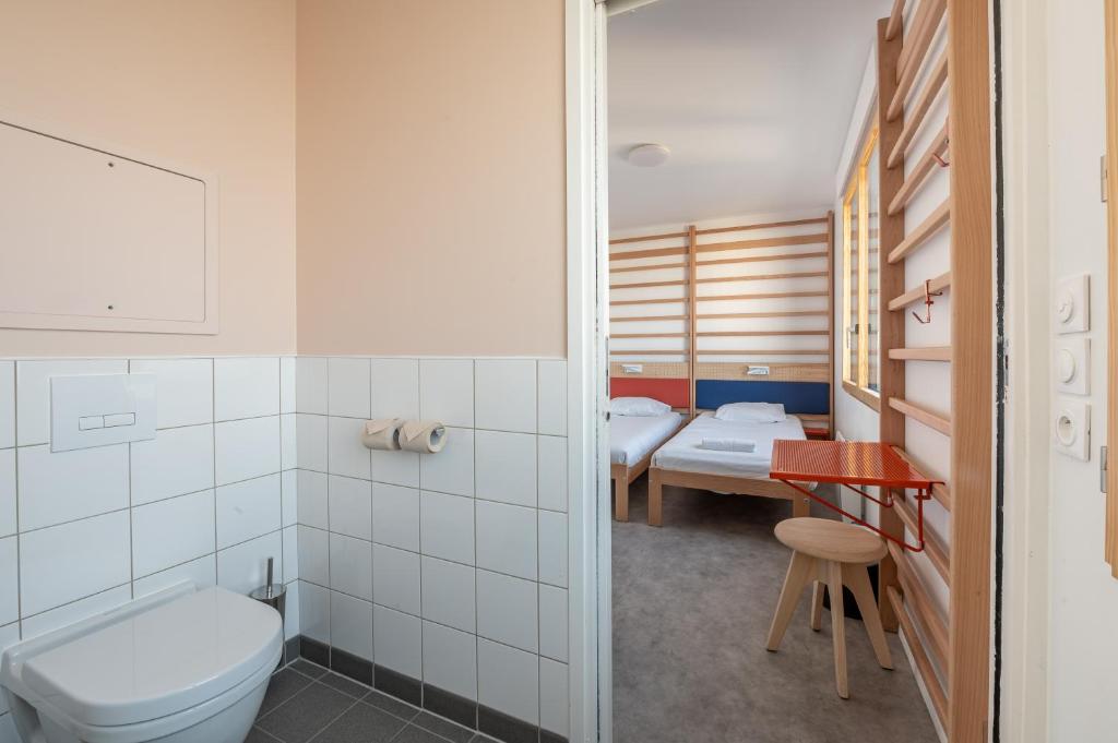 a bathroom with a toilet and two beds at UCPA SPORT STATION HOSTEL PARIS in Paris