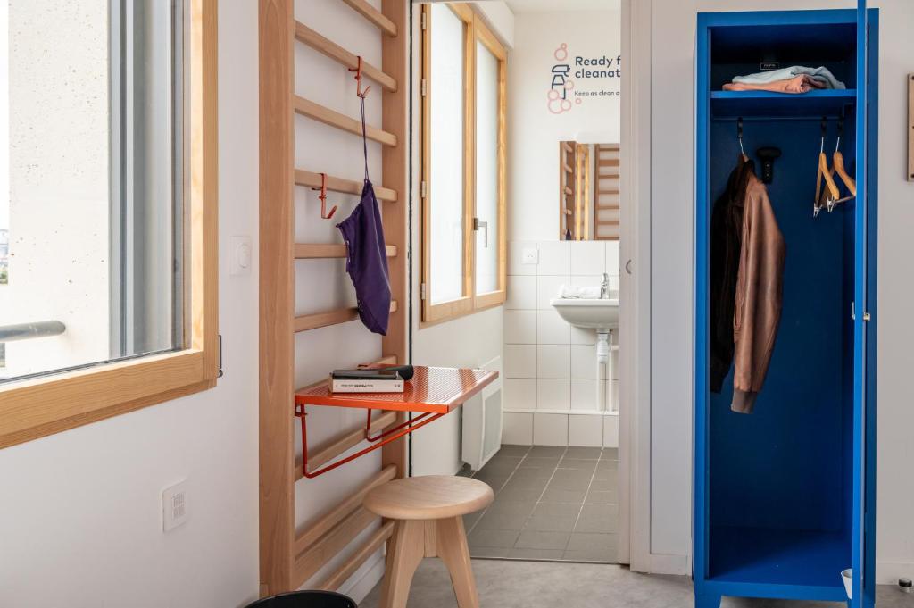 a small bathroom with a blue door and a stool at UCPA SPORT STATION HOSTEL PARIS in Paris
