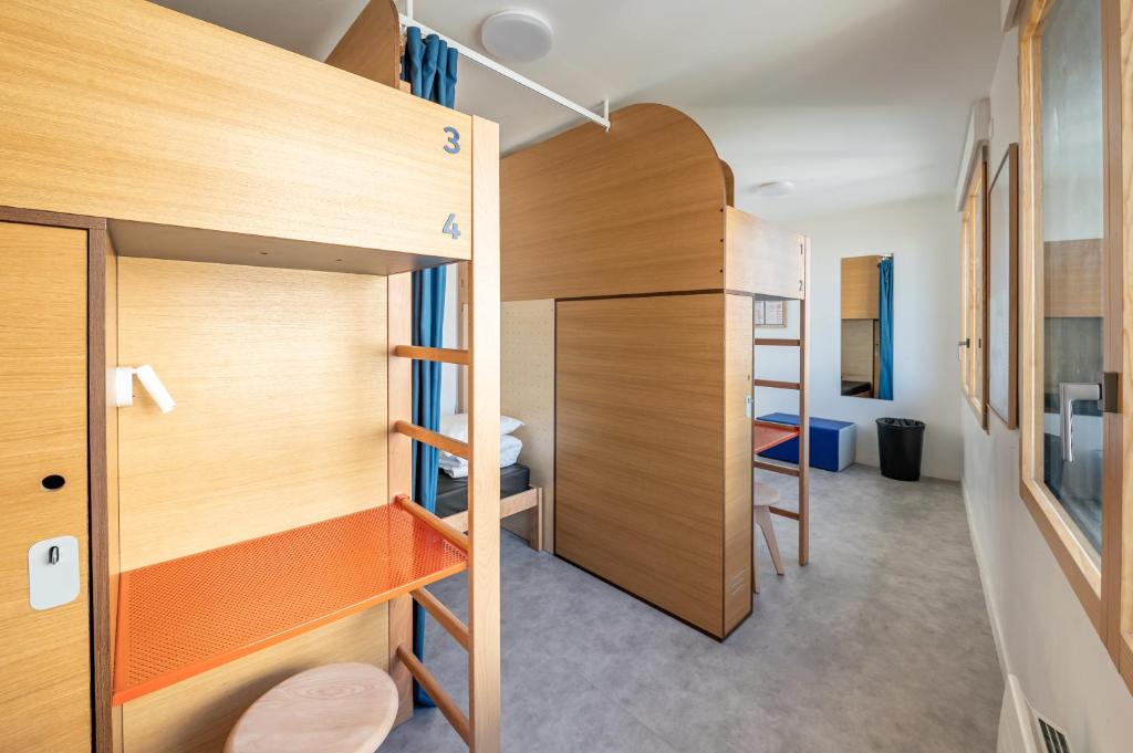 a small room with a bunk bed and a room with a ladder at UCPA SPORT STATION HOSTEL PARIS in Paris