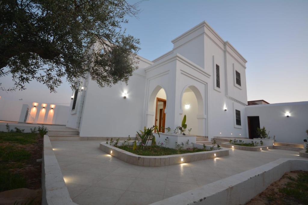 a white church with lights in front of it at Diar Nader in Midoun
