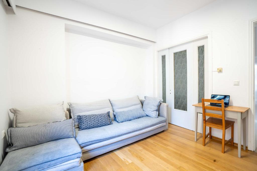 a living room with a blue couch and a table at Lefkas Town Apartment in Lefkada Town