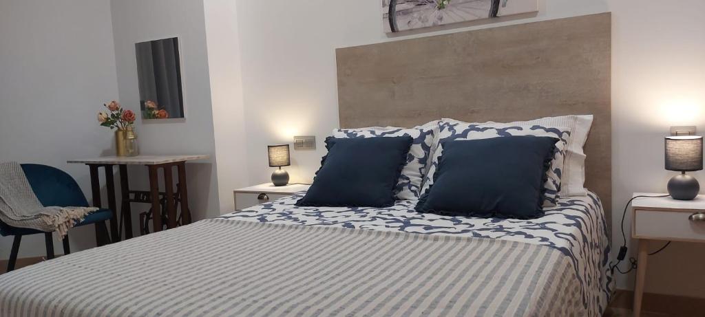 a bedroom with a bed with blue and white pillows at Casa en piedra (Stone House) in Porriño